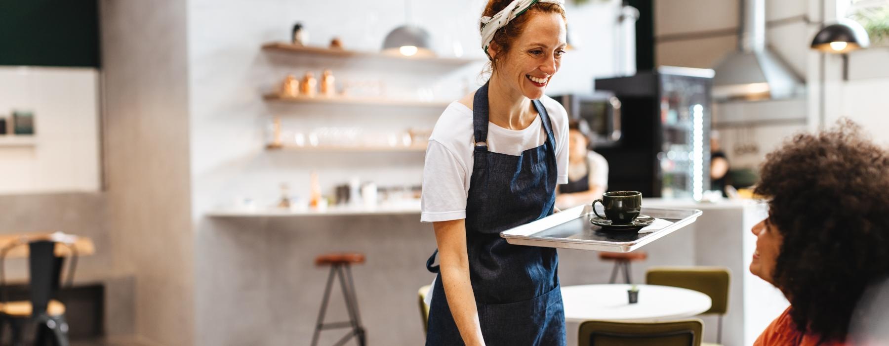 a person in a cafe being served by a barista